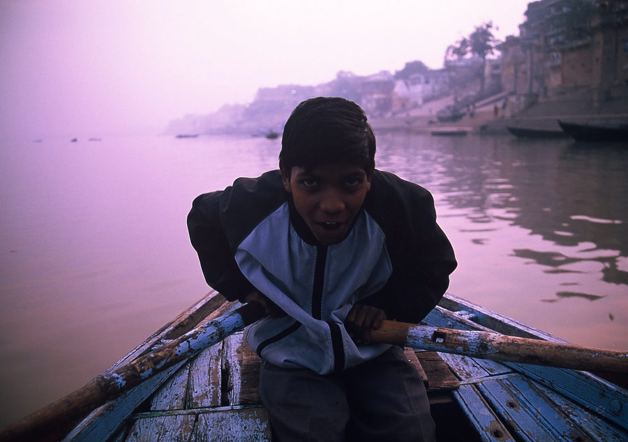 ガンジス河で舟をこいでいる少年
